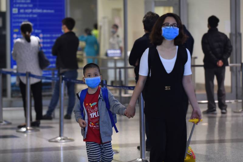 Travellers wearing protective facemasks at Noi Bai international airport in Hanoi