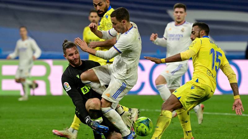 Real Madrid's Belgian forward Eden Hazard (C) fights for the ball with Cadiz's Argentinian goalkeeper Jeremias Ledesma (L) during the Spanish League match between Real Madrid CF and Cadiz CF. AFP