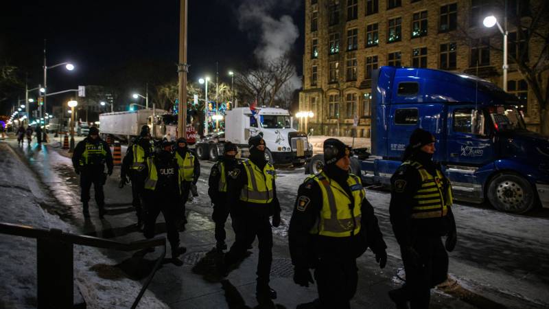 Police officers walk during a protest by truck drivers over pandemic health rules and the Trudeau government, outside the parliament of Canada in Ottawa. AFP