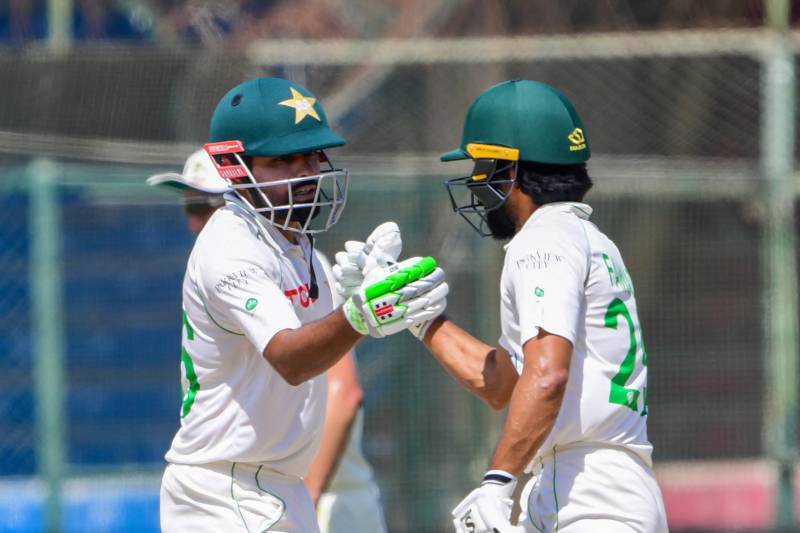Pakistan's captain Babar Azam (L) celebrates with teammate Fawad Alam after scoring 150 runs during the fifth and final day of the second Test between Pakistan and Australia at the National Cricket Stadium in Karachi. AFP