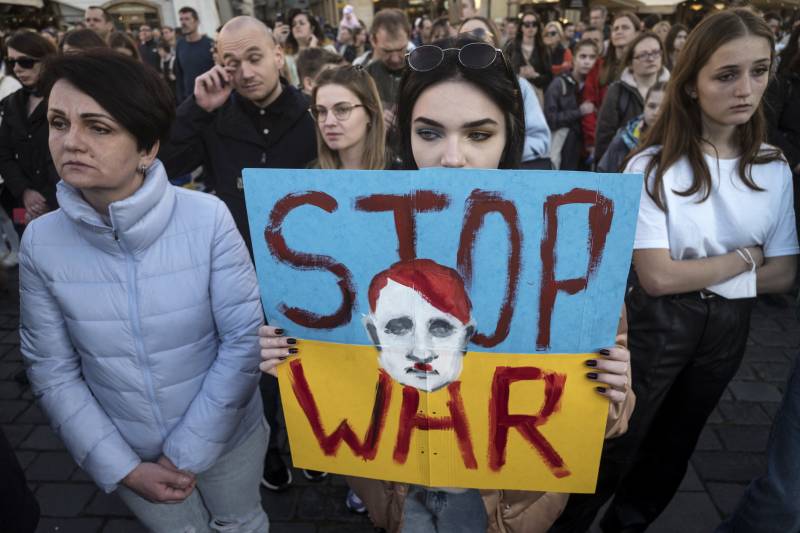 Demonstrators hold up the placards reading 'Stop War' as they watch the broadcast of international charity concert Save Ukraine - Stop War streamed from Warsaw to Old Town Square in Prague. AFP