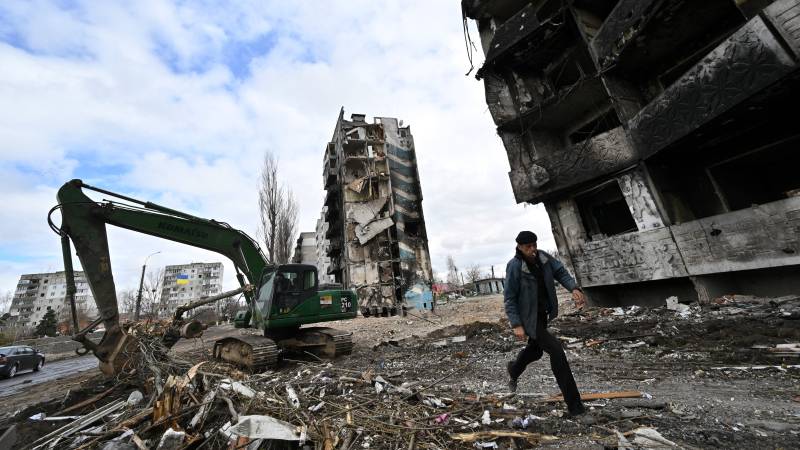 A man runs past buildings destroyed in bombardment, in the Ukrainian town of Borodianka, in the Kyiv region. AFP