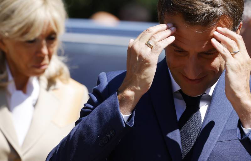 France's President Emmanuel Macron and his wife French first lady Brigitte Macron arrive to vote in French parliamentary elections at a polling station in Le Touquet, northern France on June 12, 2022.