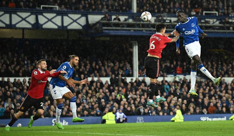 Everton's Senegalese-born Belgian midfielder Amadou Onana (R) heads the ball in the box under pressure from Manchester United's Argentinian defender Lisandro Martinez (2R) during the English Premier League football match between Everton and Manchester United at Goodison Park in Liverpool. AFP