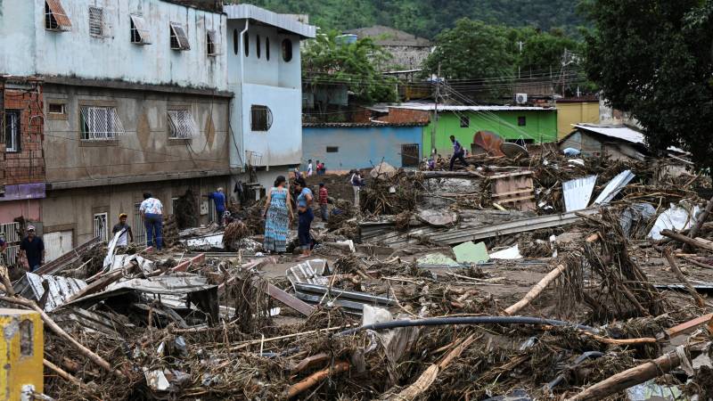Residents remain among the rubble of destroyed houses washed away by a landslide during heavy rains in Las Tejerias, Aragua state, Venezuela. AFP