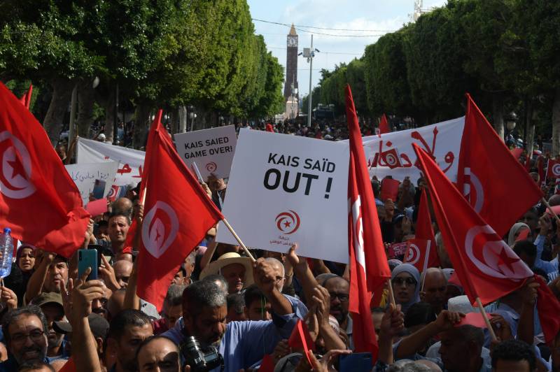 Supporters of the Tunisian Free Destourian Party wave national flags and raise placards during a demonstration against President Kais Saied in the capital Tunis. AFP