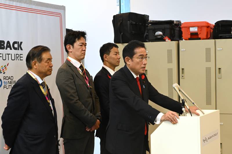 Japan's Prime Minister Fumio Kishida (R) speaks to the media. AFP