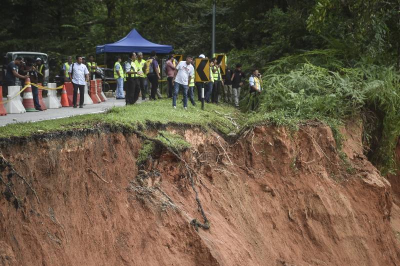 People inspect the damage after a landslide in Batang Kali, Selangor. AFP
