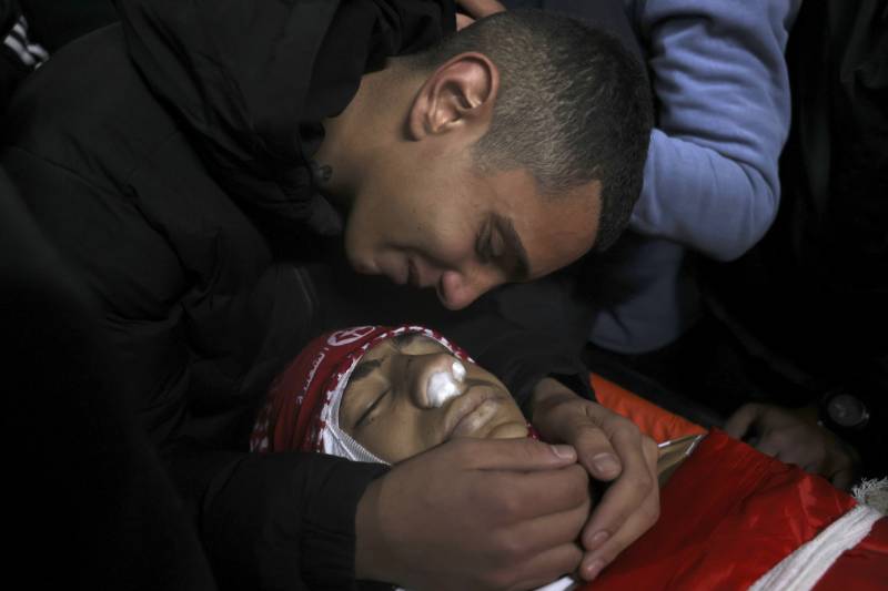 A relative mourns over the body of Omar Khmour, 14, during his funeral in Bethlehem's Dheisheh refugee camp in the occupied West Bank. AFP
