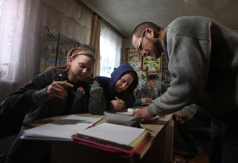 Ukrainian teacher Oleksandr Pogoryelov, 45, gives lessons to students in the living room of his house in Shandrigolovo, Donetsk region. AFP