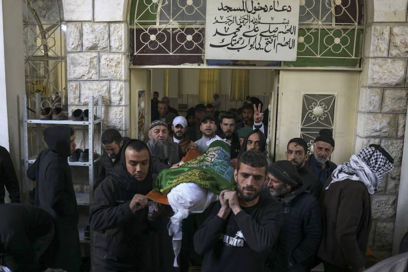 Palestinians carry the body of Nassim Abu Fouda who was killed by Israeli security forces near a checkpoint early in the morning, during his funeral in Hebron city in the occupied West Bank. AFP