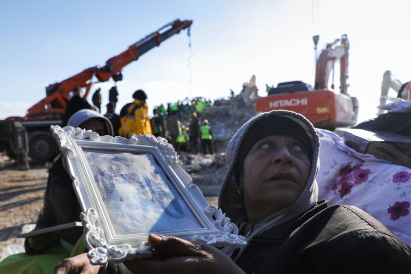 A person holds a photo as rescuers search for survivors amid destroyed buildings in Nurdagi, in the hard hit region of Gaziantep, on February 11, 2023, five days after a 7.8 magnitude earthquake struck the border region of Turkey and Syria. AFP 