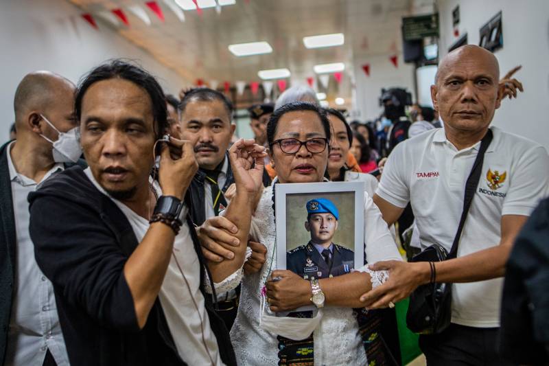 Rosti Simanjuntak (C), mother of late Brigadier Nofriansyah Yosua Hutabarat, holds a picture of her son after former head of the internal affairs for Indonesia's national police Ferdy Sambo was sentenced to death during a verdict hearing at the South Jakarta court in Jakarta. AFP