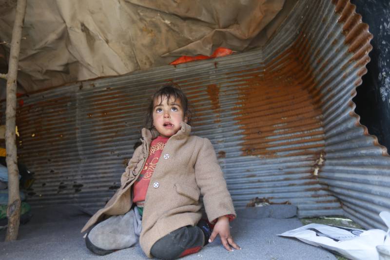 A child, displaced as a result of the earthquake that hit Turkey and Syria earlier this month, sits inside a tent at a make shift camp in Bustan al-Basha neighbourhood in the government-held northern city of Aleppo. AFP
