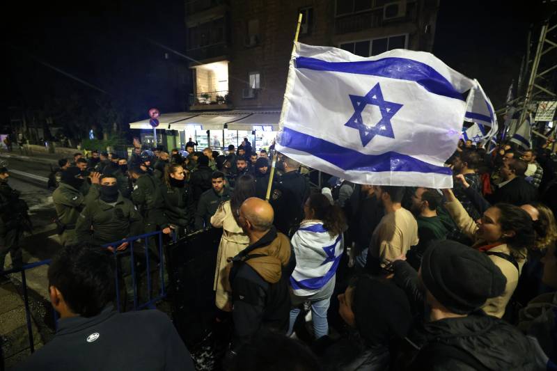 Demonstrators’ chant and wave national flags during a rally against the Israeli government's judicial reforms outside Prime Minister Benjamin Netanyahu's residence in Jerusalem. AFP