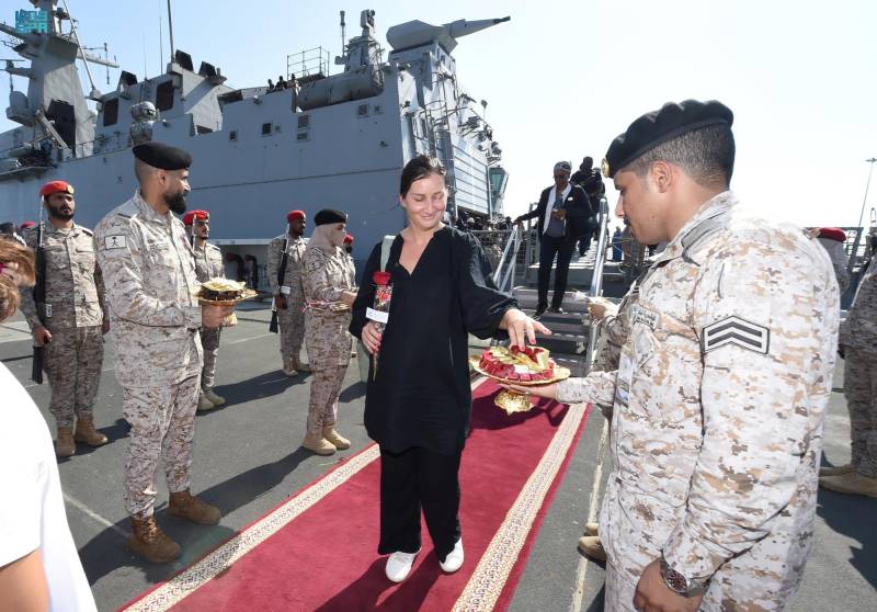 A handout picture provided by the Saudi Press Agency (SPA) on April 22, 2023, shows members of the armed forces passing out chocolates and flowers to Saudi citizens and other nationals upon their arrival in Jeddah, following their rescue from Sudan. AFP