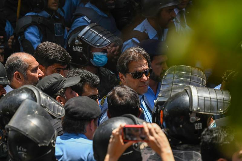 Policemen escort Pakistan's former Prime Minister Imran Khan (C) as he arrives at the high court in Islamabad. AFP