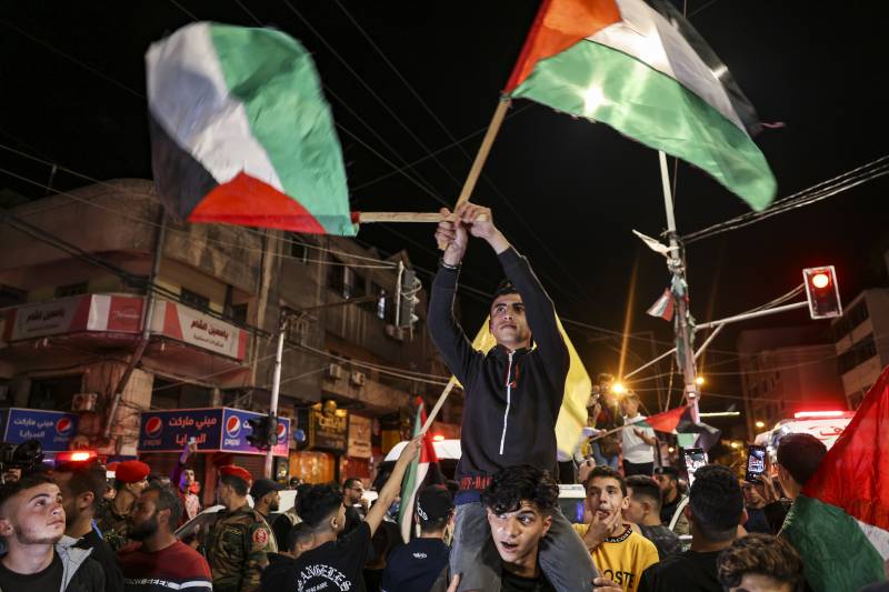 Palestinians and supporters of the Islamic Jihad Movement celebrate in the street after Palestenian factions and Israel reached a ceasefire agreement in Gaza City on May 13, 2023. AFP 