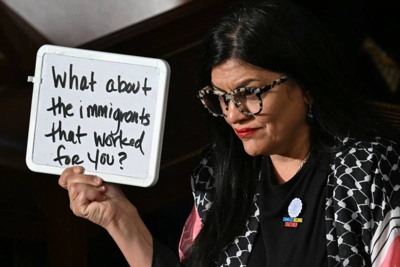 Muslim Democrat holds up sign as Trump speaks