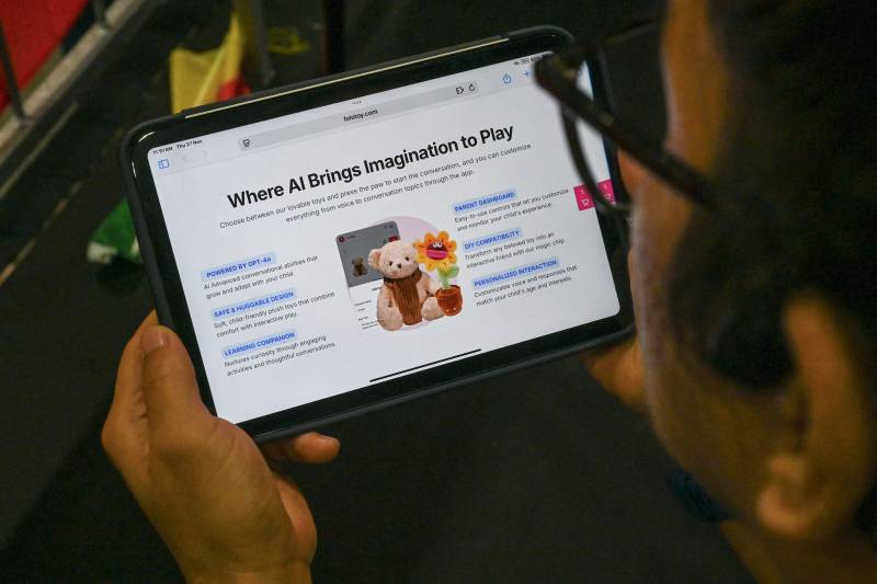 A person looks at a screen displaying a website selling a Singapore-made teddy bear equipped with AI in Singapore. AFP